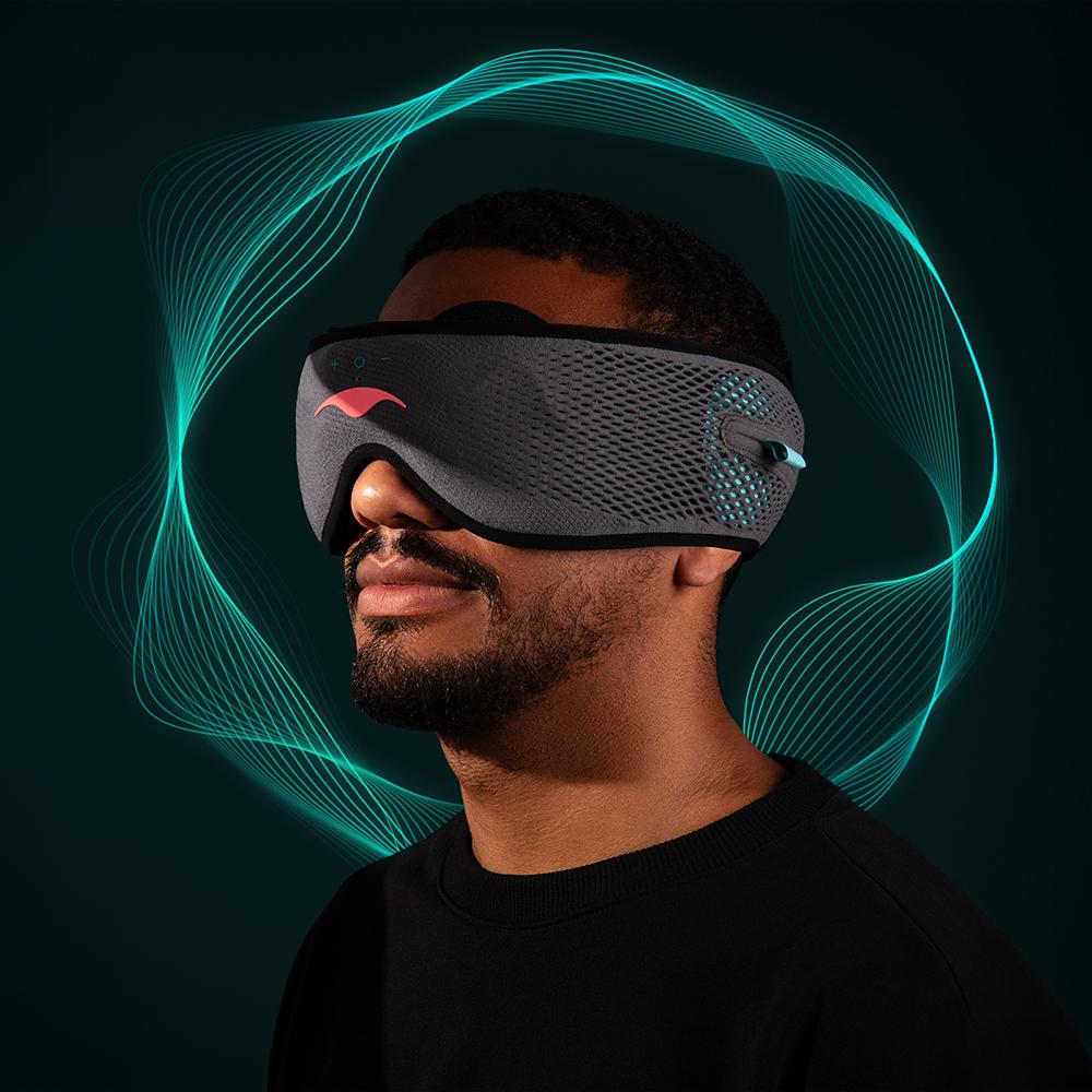 A man wearing a gray mesh with blue wavy lines surrounding his head.