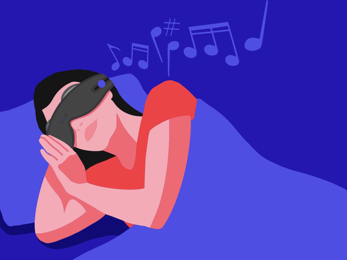 A girl wearing a sleep mask with headphones in bed listening to music.