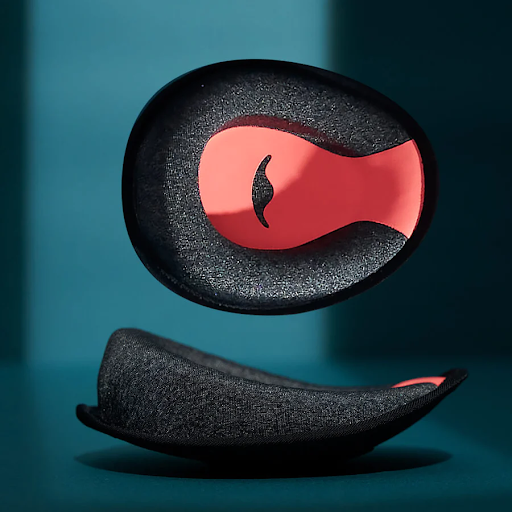 A pair of black and orange C-shaped eye cups for a sleep mask with headphones.